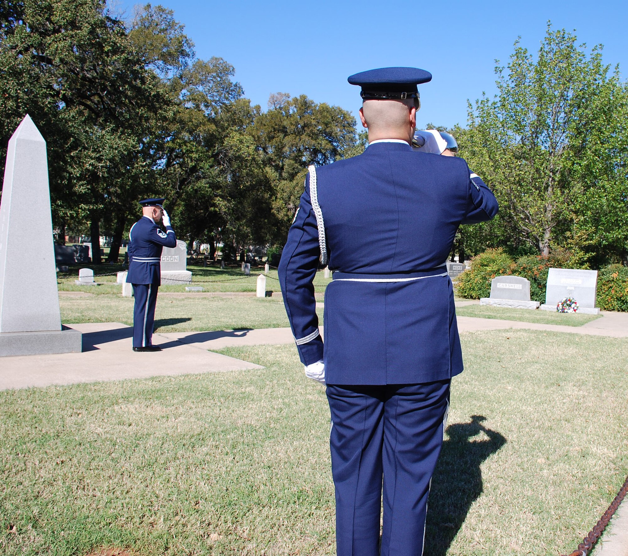 Staff Sgt. Marc Coopershedfield, 301st Fighter Wing Honor Guard member, plays taps after laying a wreath on the resting place of Maj. Horace Carswell while Master Sgt. Ross Wood, Honor Guard superintendent, pays respect. Major Carswell was shot down over China on Oct. 26, 1944 and the base, in Fort Worth, Texas, was named after the major in 1948 and is now is home to all branches of the U.S. armed forces. including the Air Force Reserve. (U.S. Air Force Photo/Tech. Sgt. Julie Briden-Garcia) 