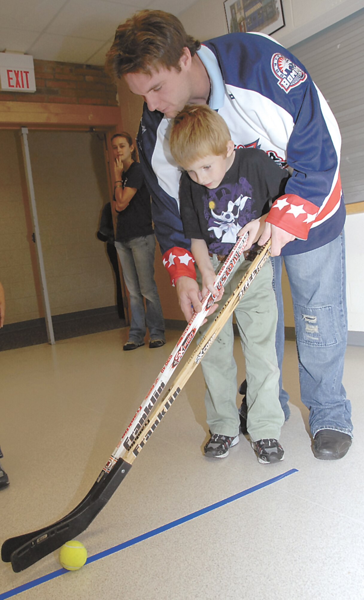 Dayton Bombers player Chanse Fitzpatrick gives some tips to Chance Sanders at the booth he was working to celebrate the Lights On After School program at Wright-Patterson Air Force Base. (Christy Webb/Skywrighter photo)