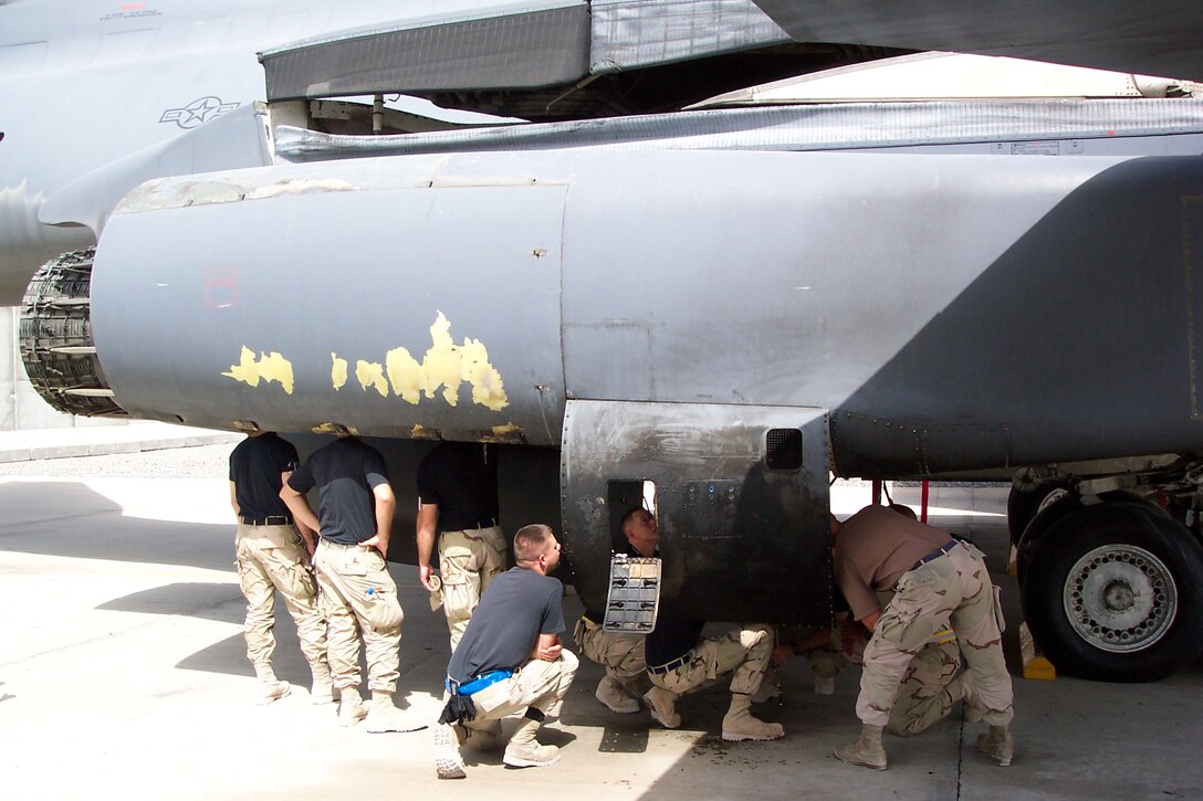 Enlisted members from the 654th Combat Logistics Support Squadron examine the damaged B-1 in a forward operating location within the U.S. Central Command area of responsibility. (Air Force photo)