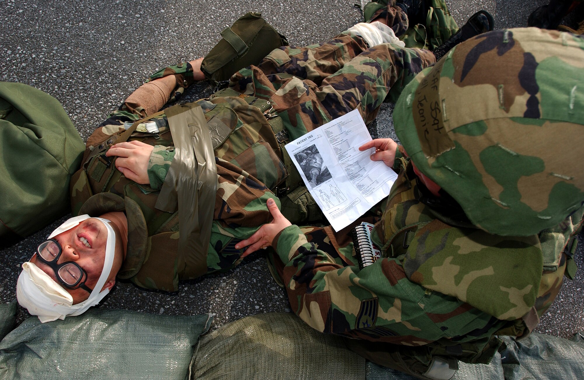 Staff Sgt. Jeanie Campbell cares for a simulated injured Airman with multiple wounds and keeps the victim conscious during a simulated explosion at Kadena Air Base, Japan, Oct. 24. The mass casualty scenario helped Airmen train on treating wounds and applying basic life-saving steps during Local Operational Readiness Exercise Beverly High 08-1. Sergeant Campbell is assigned to the 18th Communications Squadron. (U.S. Air Force photo/Tech. Sgt. Rey Ramon) 