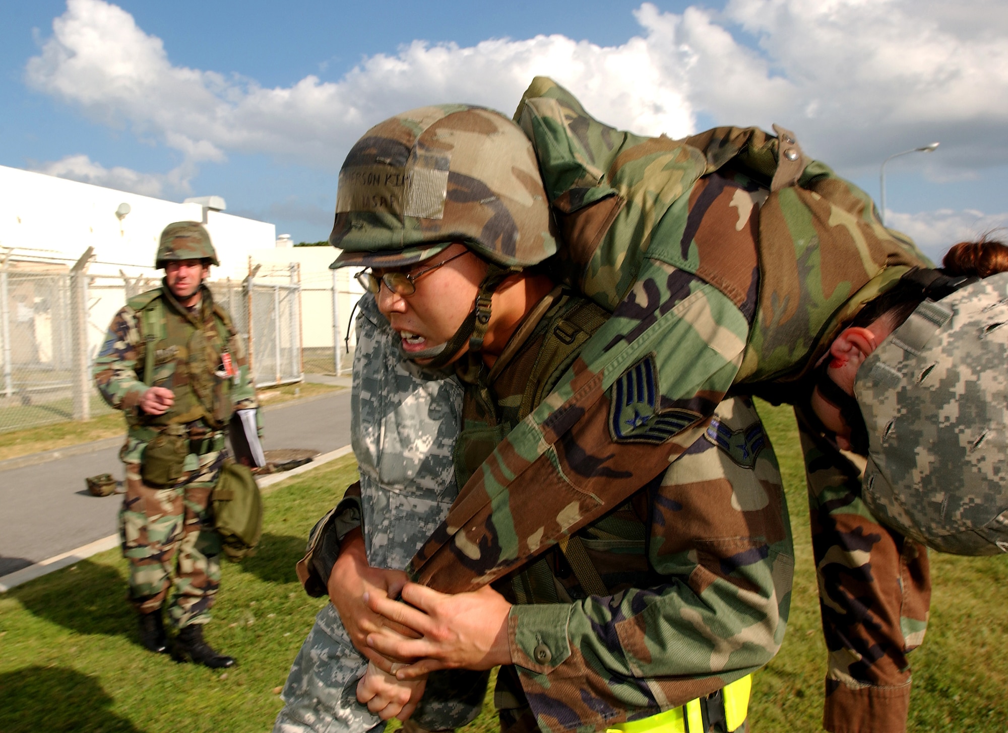 Airman 1st Class Emerson Kim carries an injured Airman during a simulated fire explosion at Kadena Air Base, Japan, Oct. 24. The mass casualty scenario helped Airmen train on treating wounds and applying basic life-saving steps during the Local Operational Readiness Exercise Beverly High 08-1. Airman Kim is assigned to the 18th Communications Squadron. (U.S. Air Force photo/Tech. Sgt. Rey Ramon) 

