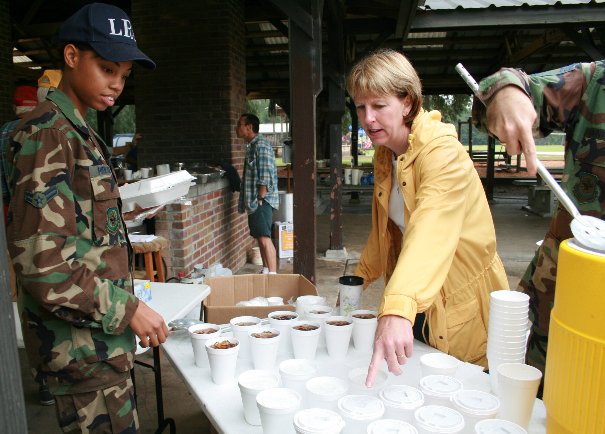 Chief Master Sgt. Maureen Adkins, 315th Mission Support Squadron, explains the drink selection to Airman 1st Class Karla Pierson, 437th Logistic Readiness Squadron, Charleston AFB, S.C., at the Charleston Chiefs group fish fry held at the base picnic grounds. (Photo by Kirsty Murray)