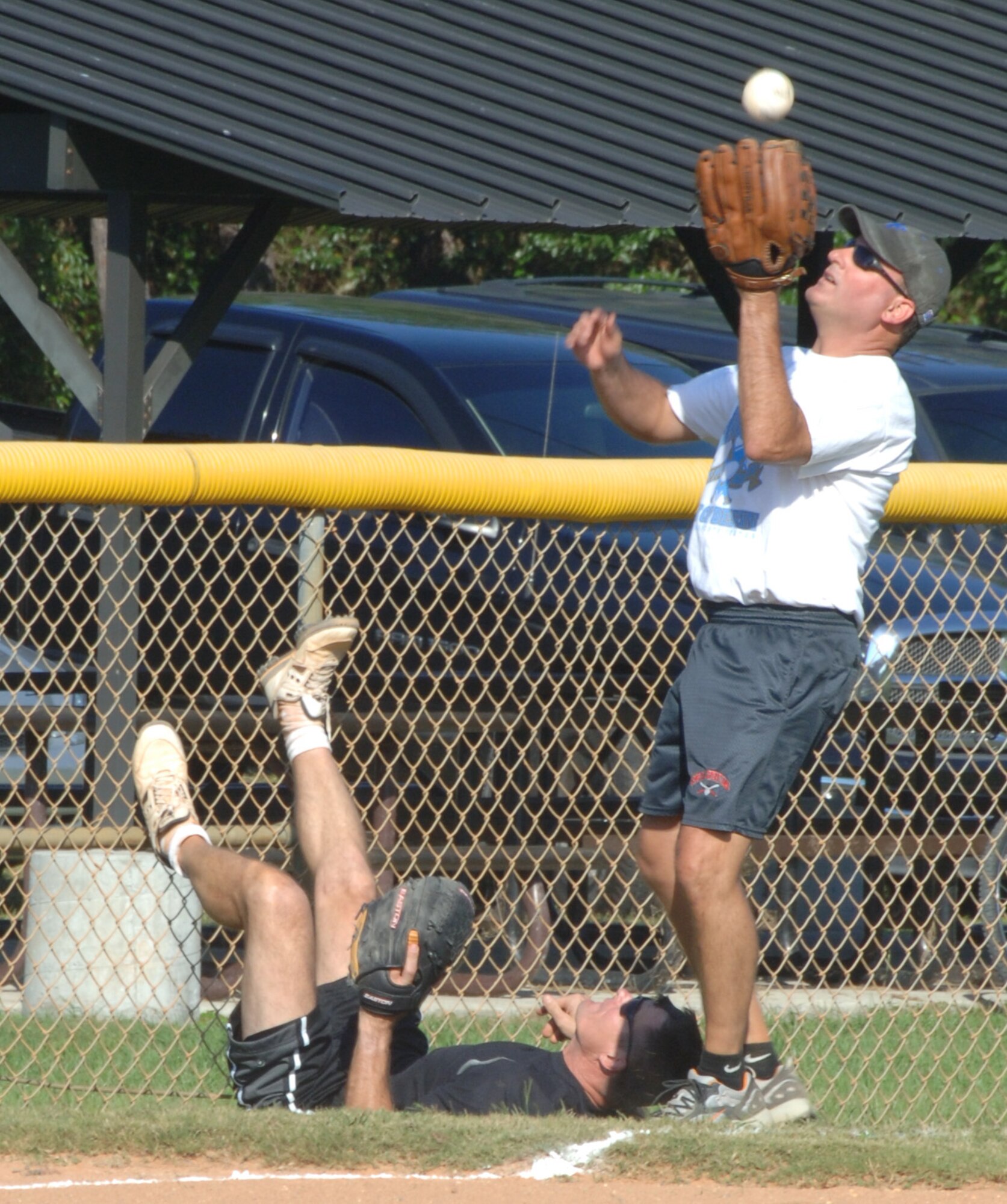 A member of the Eagles' softball team goes for the catch after a fellow team member took an unfortunate spill. The Eagles and Chiefs softball game is a standing tradition at Hurlburt Field in which the base’s colonels, the Eagles, take on the base's chief master sergeants, the Chiefs. (U.S. Air Force photo by Airman Matthew Loken)
