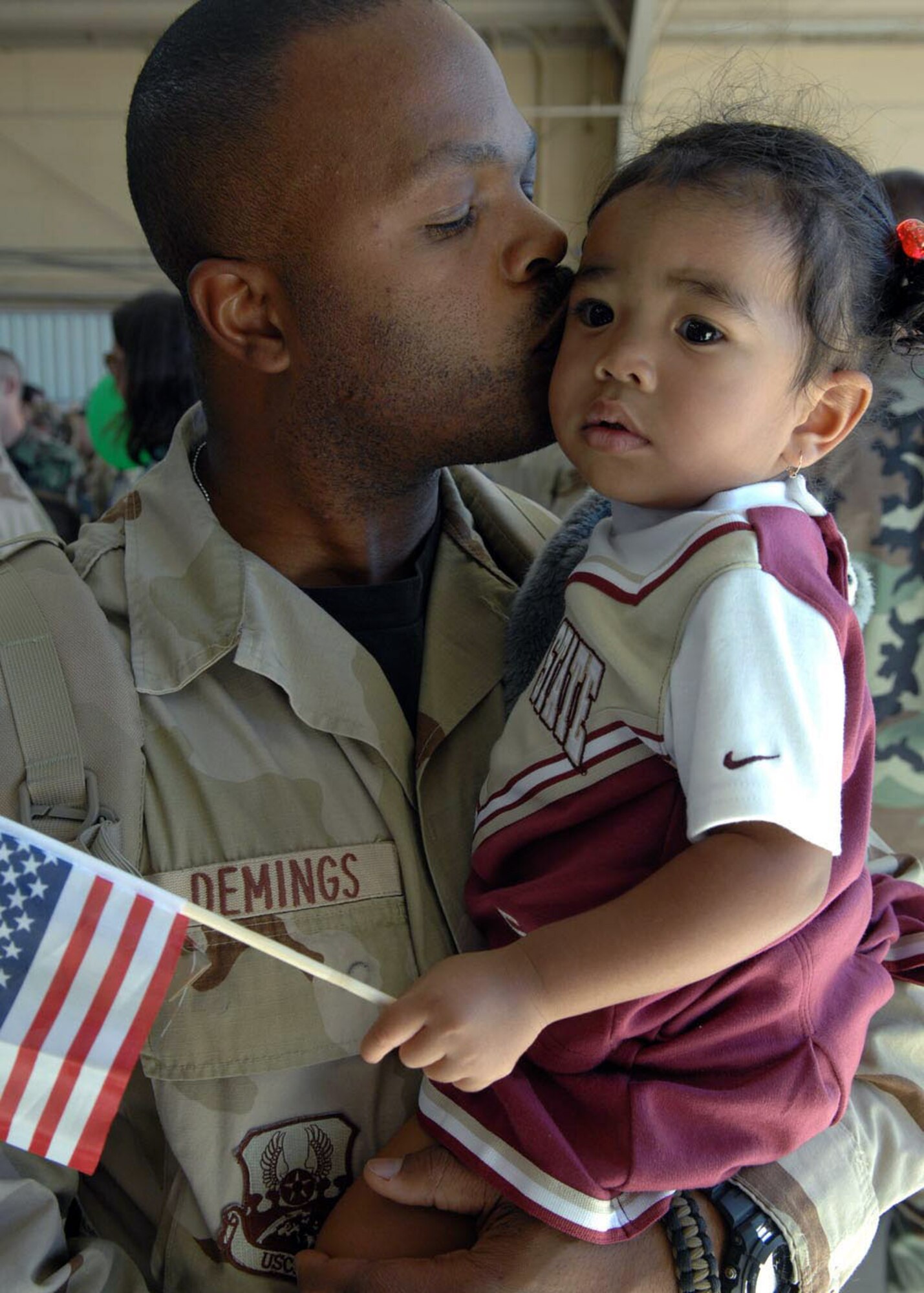 Tech Sgt. Kenyatta Demings kisses the forehead of his 19-month-old daughter Myka, after returning to home Oct. 23 from a deployment to Afghanistan. Sergeant Demings is a munitions inspector assigned to the 355th Equipment Maintenance Squadron, at Davis-Monthan Air Force Base, Ariz. (U.S. Air Force photo/Senior Airman Christina D. Kinsey) 