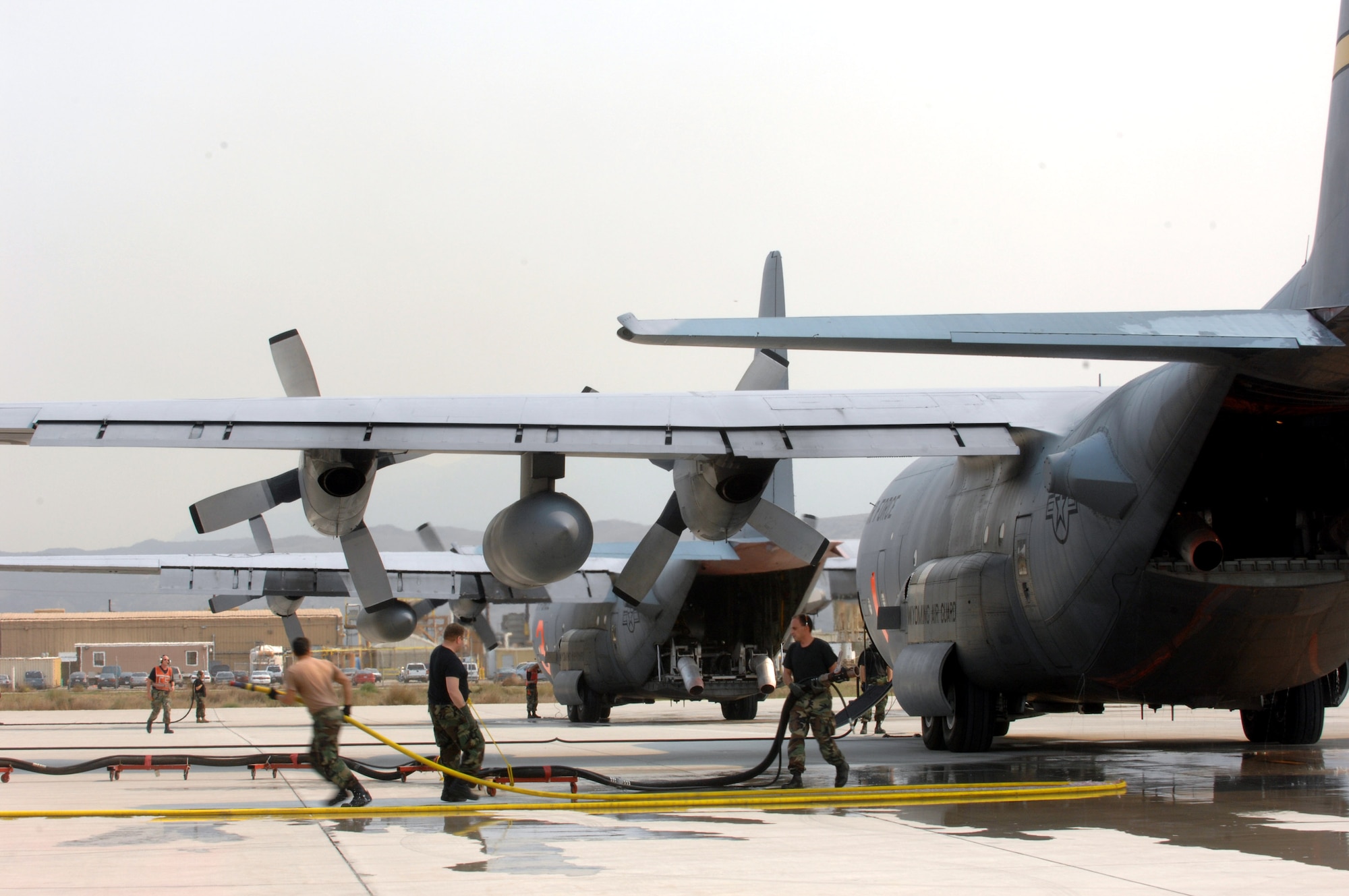 Members from the 145th Maintenance Squadron from Charlotte, N.C., pull a fire retardant hose after filling the Module Air Fire Fighting System with fire retardant on a C-130 Hercules during a refueling stop Oct. 25 at Channel Islands Air National Guard Base, Calif. Air Force Reserve Command and Air National Guard Airmen are participating in the Southern California firefighting effort. (U.S. Air Force photo/Staff Sgt. Hector Garcia) 
