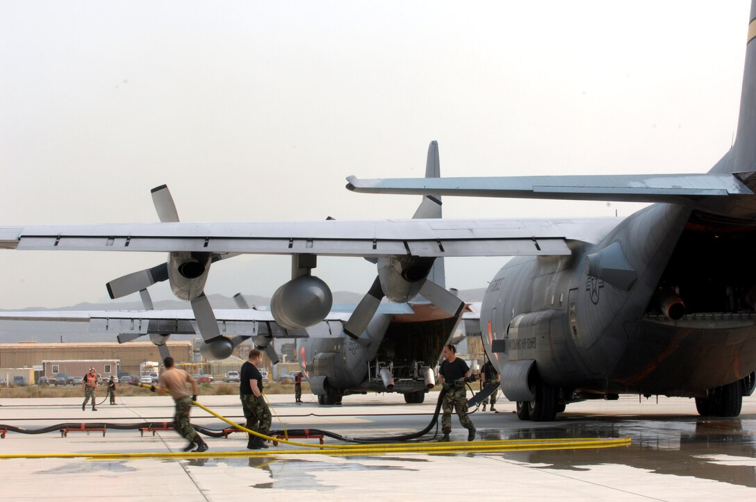 Members from the 145th Maintenance Squadron from Charlotte, N.C., pull a fire retardant hose after filling the Module Air Fire Fighting System with fire retardant on a C-130 Hercules during a refueling stop Oct. 25 at Channel Islands Air National Guard Base, Calif. Air Force Reserve Command and Air National Guard Airmen are participating in the Southern California firefighting effort. (U.S. Air Force photo/Staff Sgt. Hector Garcia) 
