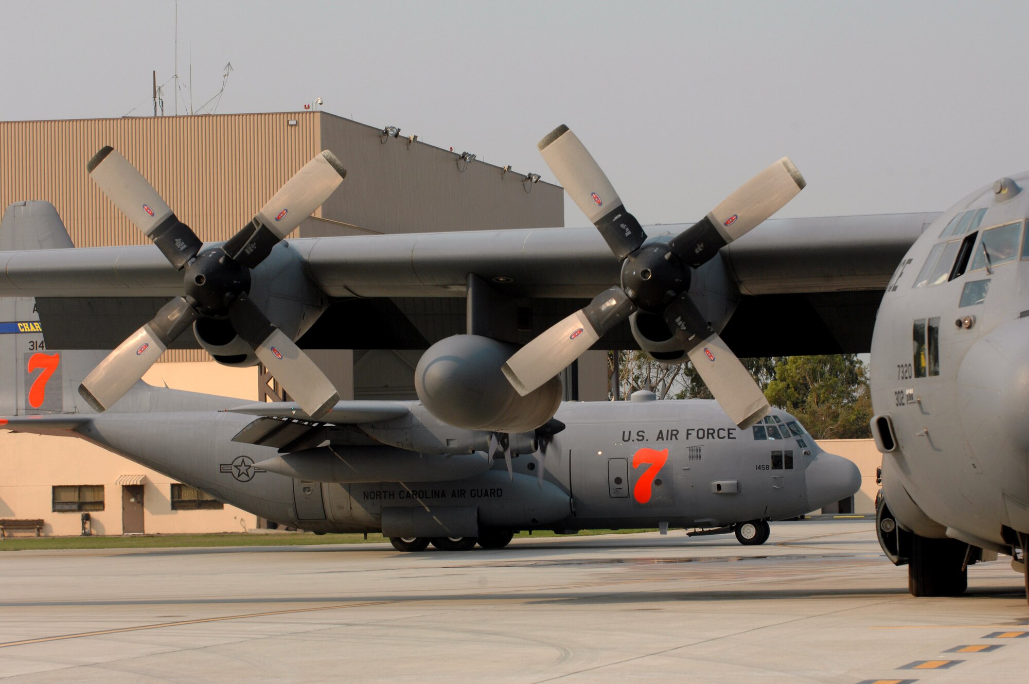 A C-130 Hercules awaits deployment in the reloading pits to support the California firefighting efforts Oct. 25 as a C-130 taxis in at Channel Islands Air National Guard Base, Calif. Air Force Reserve Command and Air National Guard Airmen are participating in the Southern California firefighting effort. (U.S. Air Force photo/Staff Sgt. Hector Garcia) 
