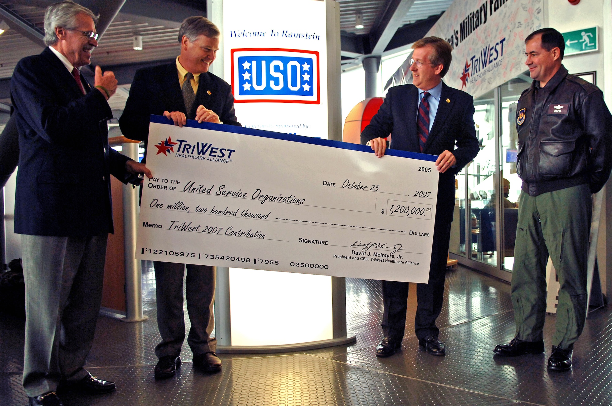 (From left) Mr. Bill Moll, United Service Organizations (USO) chairman of the board of governors, and The Honorable Edward A. Powell, USO Jr, president and chief executive officer, accept a donation of 1,200,000 dollars from Mr. David McIntyre, TriWest Healthcare Alliance president and chief executive officer, with the company of Major General Marc Rogers, U.S. Air Forces in Europe vice commander, on Ramstein Air Base, Germany, Oct. 25. The donation will be used to assist the USO in its world-wide mission to serve and support America's sons and daughter in war. The Ramstein Passenger Terminal USO will receive $150,000 dollars of the donation for continued upgrades and maintenance. (U.S. Air Force photo/Airman 1st Class Marc I. Lane)