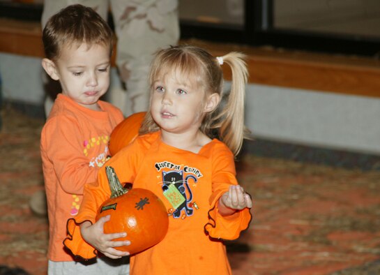 SHAW AIR FORCE BASE, S.C. -- Joseph Banaszek, son of Brandi and Senior Airman Joseph Banaszek, 20th Component Maintenance Squadron, and Trinity Graham, daughter of Dawn and Staff Sgt. Christopher Graham, 20th Medical Support Squadron, carry thier pumpkins they decorated for the Shaw CDC Harvest Fest Oct. 25. (U.S. Air Force photo/Tech. Sgt. Kevin Williams) 