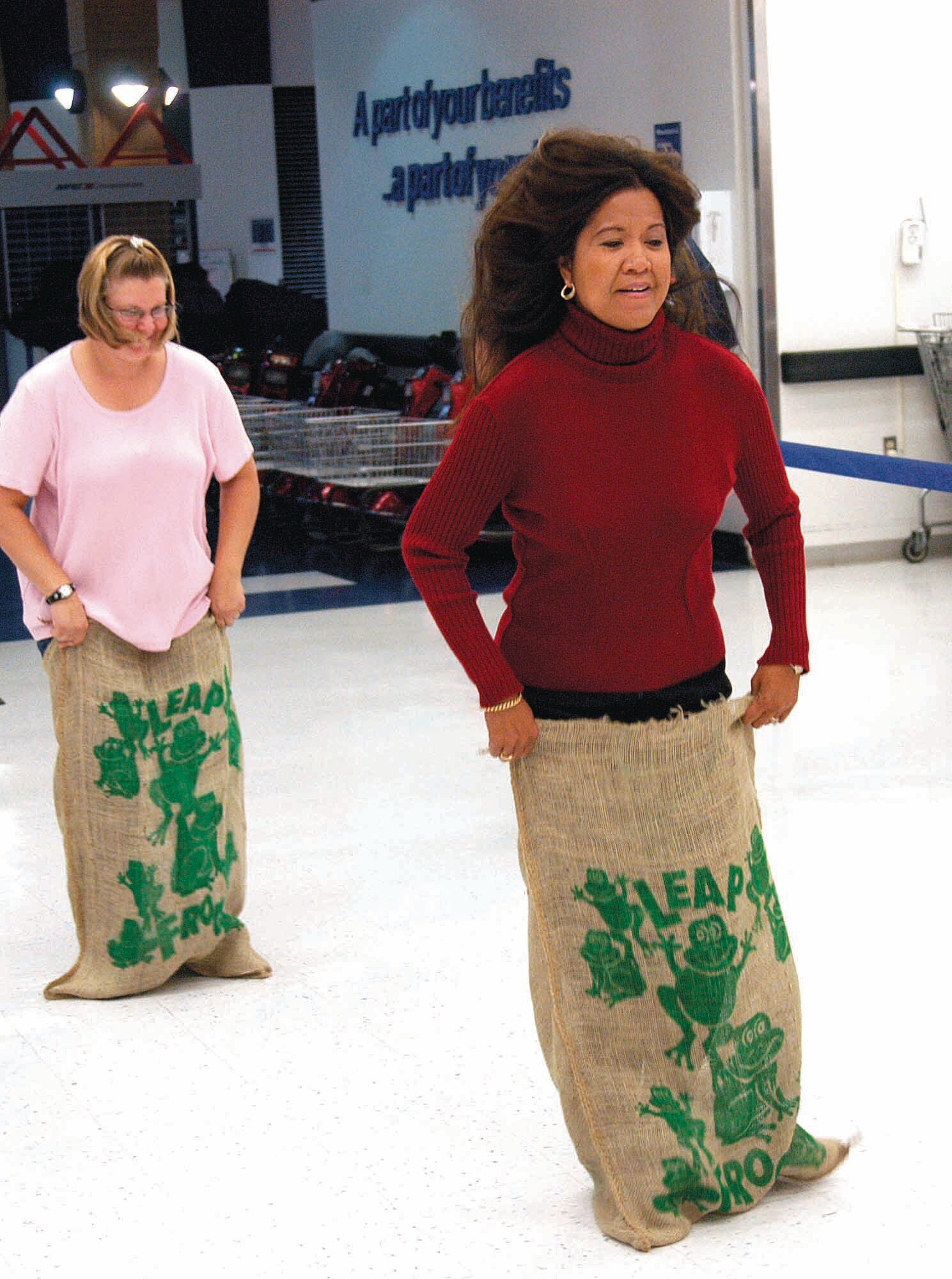 Rosalina Johnson hops her way to victory in a sack race against Gail Snyder and Deborah  Jenkins (not pictured) during the Base Exchange’s Combined Federal Campaign kick off rally held before the store opened Oct. 17.  (Air Force photo by Margo Wright)