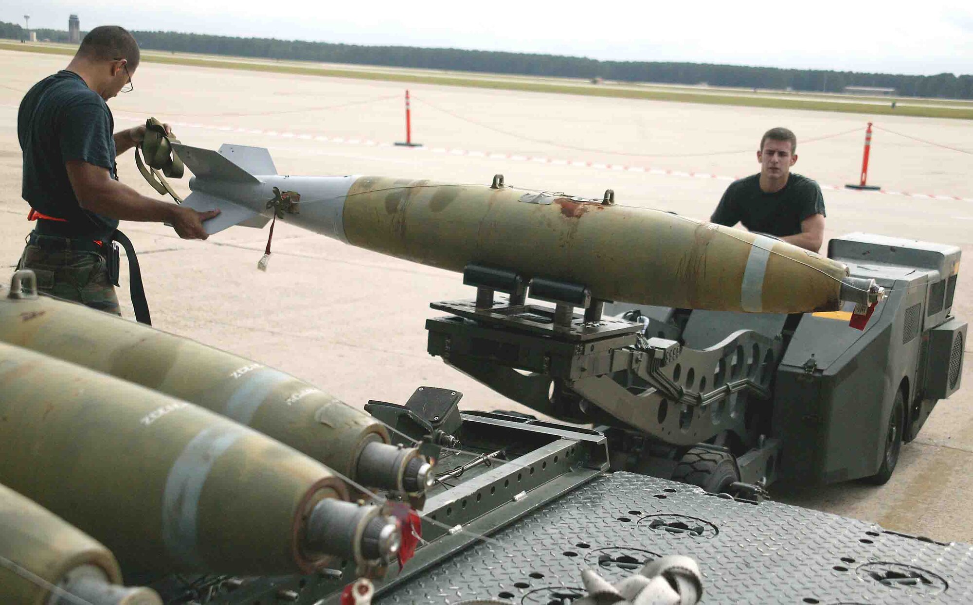 SHAW AIR FORCE BASE, S.C. -- Staff Sgt. David Burgos (left), 79th Aircraft Maintenance Unit weapons loader, helps guide the simulation bomb that is being moved to the F-16CJ while Senior Airman Jason Bachtel, 79th AMU weapons loader, drives the loading vehicle during a weapons load crew competition Oct. 19. "The weapons load crew competition program is designed to promote morale and to increase proficiency, knowledge, professionalism and integrity," said Jeffrey McLaughlin, 20th Maintenance Group loading standardization crew member. (U.S. Air Force photo/Staff Sgt. John Gordinier)