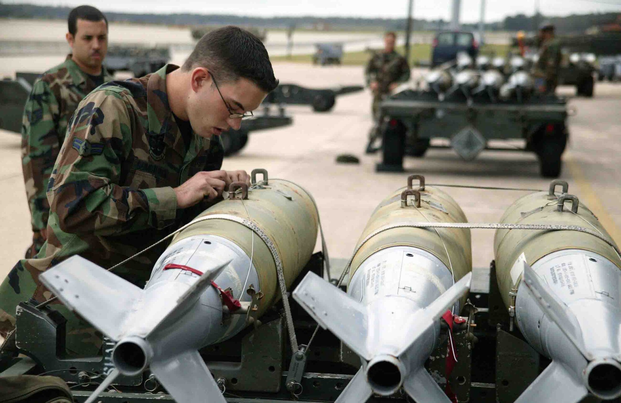 SHAW AIR FORCE BASE, S.C. -- Airman 1st Class John Bumbalough, 55th Aircraft Maintenance Unit weapons loader, prepares the simulated bombs for attachment to an F-16CJ during a weapons load crew competition Oct. 19. "The weapons load crew competition program is designed to promote morale and to increase proficiency, knowledge, professionalism and integrity," said Jeffrey McLaughlin, 20th Maintenance Group loading standardization crew member. (U.S. Air Force photo/Staff Sgt. John Gordinier)