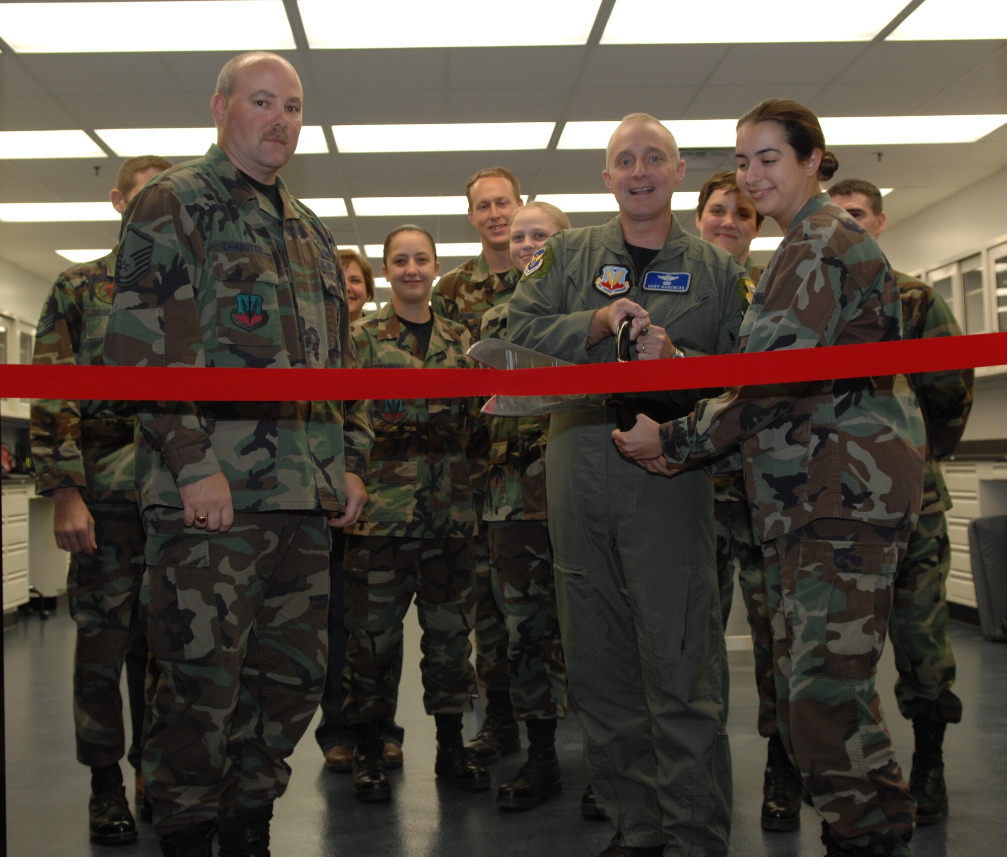 WHITEMAN AIR FORCE BASE, Mo. -- Col. Garrett Harencak, 509th Bomb Wing commander, cuts a ribbon with help from 1st Lt.  Heidi Grandin, 509th Medical Operations Squadron, during a ribbon cutting ceremony for Bioenvironmental Engineering Oct. 24. Bioenvironmental Engineering is responsible for performing full spectrum health risk assessments including the areas of industrial hygiene, environmental surveillance, radiological monitoring of chemical, biological, radiological and nuclear detection and quantification. (U.S. Air Force photo/Airman 1st Class Stephen Linch)