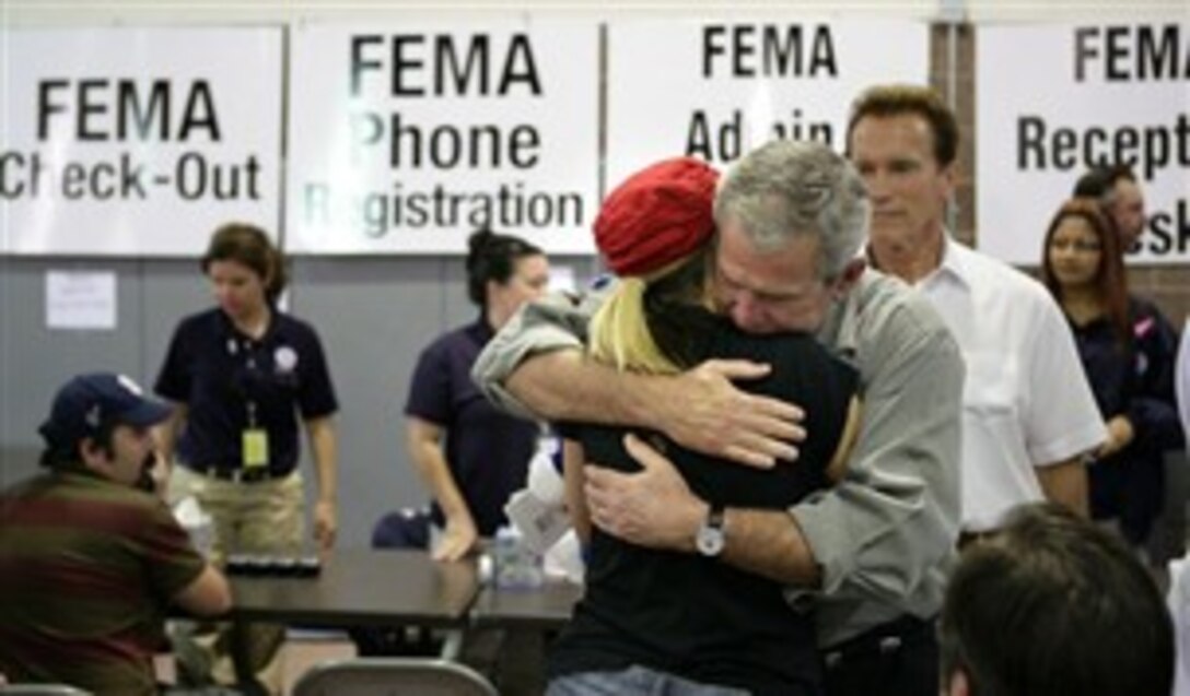 President George W. Bush hugs a woman, Oct. 25, 2007, at a Federal Emergency Management Agency emergency center in Rancho Bernardo, Calif. Bush visited the southern California area hard hit by recent wildfires, consoling those who lost their homes and commending those whose efforts saved others. 