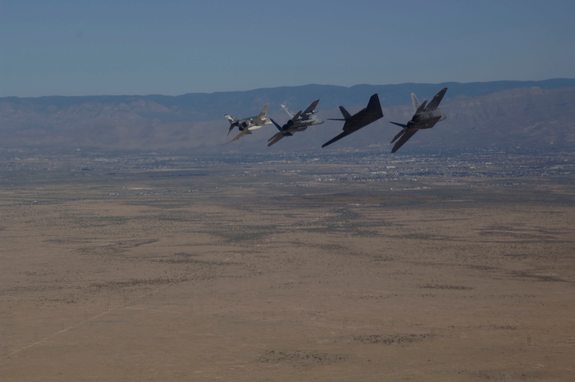 An F-15 Eagle, F-4 Phantom, F-117 Nighthawk, and F-22 Raptor fly in formation over Holloman Air Force Base, NM during the Holloman Air and Space Expo on October 27, 2007. The HASE is a showcase of Air Force capabilities, the 49th Fighter Wing mission and the X Prize Foundation. (U.S. Air Force photo by Senior Airman Russell Scalf)
