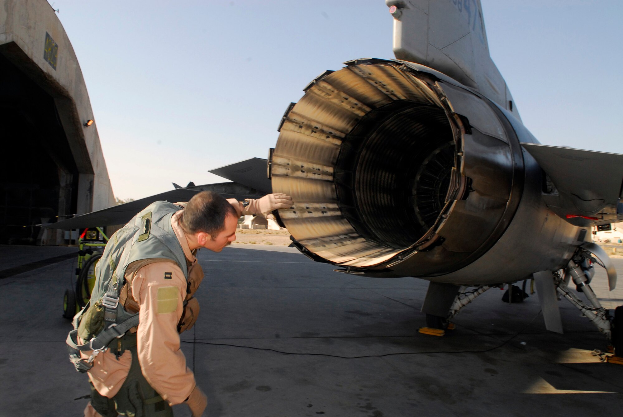 BALAD AIR BASE, Iraq -- Capt. Thomas "Shack" Graham, 4th Expeditionary Fighter Squadron, inspects the exhaust of his F-16 Fighting Falcon. The exterior and interior of the aircraft are examined to ensure that everything is operating properly. Captain Graham is deployed from Hill Air Force Base, Utah. (U.S. Air Force photo/Staff Sgt. Joshua Garcia)