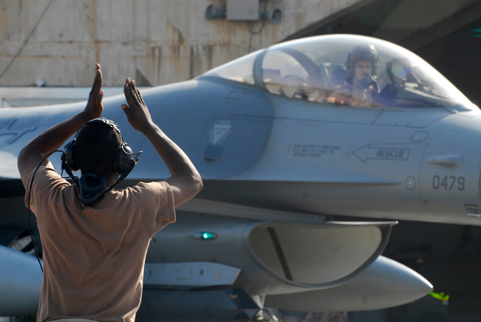 BALAD AIR BASE, Iraq -- Airman 1st Class Martin Johnson, 332nd Expeditionary Aircraft Maintenance Squadron crew chief, marshals Capt. Thomas "Shack" Graham, 4th Expeditionary Fighter Squadron, to the flightline. Airman Johnson tells the pilot when it is safe to taxi to the runway. Both Captain Graham and Airman Johnson are deployed from Hill Air Force Base, Utah. (U.S. Air Force photo/Staff Sgt. Joshua Garcia)