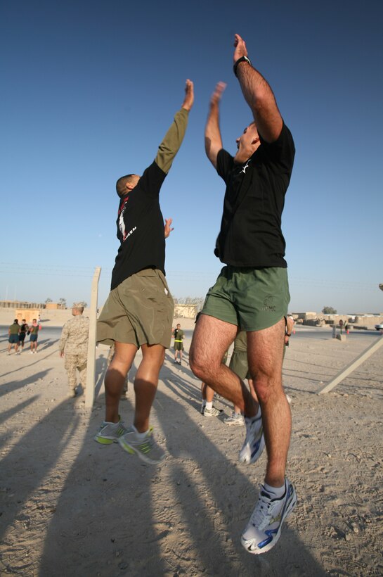 AL TAQADDUM, Iraq (Oct. 28, 2007) ? Lance Cpl. Kenneth W. Smith and Cpl. Shelby A. Ochs perform a jumping high-five in their Halloween 5k run T-shirts after finishing the event Oct. 28.  Nearly 500 service members and civilian contractors aboard Al Taqaddum participated in the run.  Smith is a Unit Movement Control Center clerk from San Francisco and Ochs is the embarkation noncommissioned officer-in-charge for 2nd Marine Logistics Group (Forward) and a Washington, D.C., native.  Both Marines are with Headquarters Company, 2nd MLG (Fwd).