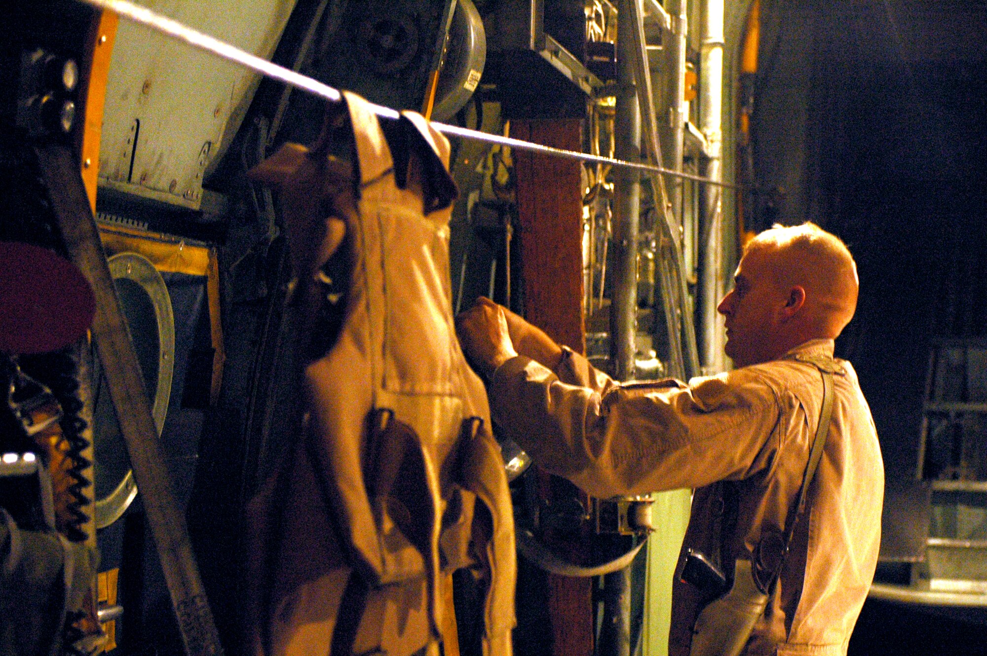 SOUTHWEST ASIA - Tech. Sgt. Kevin Letz, 40th Expeditionary Airlift Squadron loadmaster, secures the side troop doors of a C-130 prior to take off. Sergeant Letz is deployed here from Dyess Air Force base, Texas. The 40th EAS took over for the 746th EAS here recently. (U.S. Air Force photo/Staff Sgt. Jason Barebo)