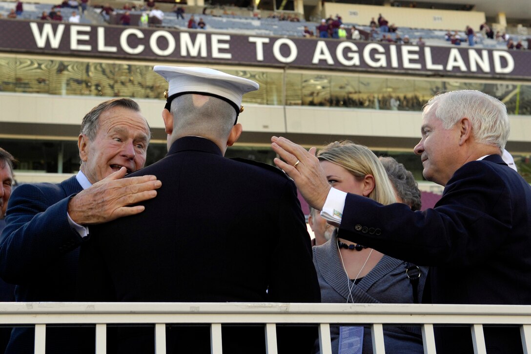 President George H.W. Bush and Defense Secretary Robert M. Gates greet U.S. Marine 1st Lt. Dan Moran and his wife Teal during the University of Kansas-Texas A&M football game in College Station, Texas, Oct. 27, 2007. 