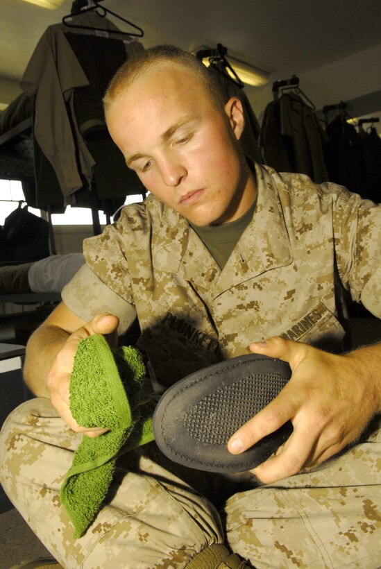 Pvt. Evan Plunkett, Platoon 2146, Company G, cleans his dress shoes Monday for the battalion commander?s inspection.