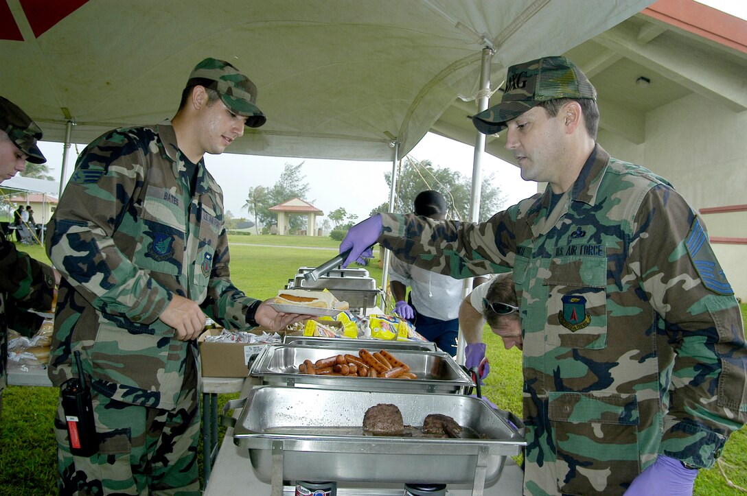 Chief Master Sgt. James Cornell, 36th Maintenance Group, serves a hot dog to Senior Airman Christopher Bates, 36th Logistic Readiness Squadron, during the annual Andersen Junior Enlisted Appreciation Day Oct 26. (U. S. Air Force photo/ Master Sgt. Lisa M. Zunzanyika)   