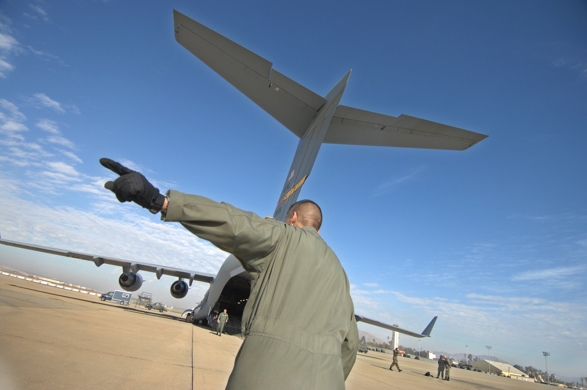 TSgt Sergio Melendez, a loadmaster from the 729th AS at March Air Reserve Base, Calif., signals to drivers to ready their vehicals as they prepare to load a C-17A Globemaster Sunday October 28th, 2007. The C17 crew is redeploying the 375th to Scott AFB, IL. The 375th AES was assigned to the Mobile Aeromedical Staging Facility at March Air Reserve Base, Calif., in support of medical relief efforts for the California wildfires. The 375th along with other aeromedical components from Pope AFB, N.C., and Travis AFB, Calif., were on standby to air-evacuate fire victims out of the local area. U.S. Air Force photo by MSgt Rick Sforza (RELEASED)