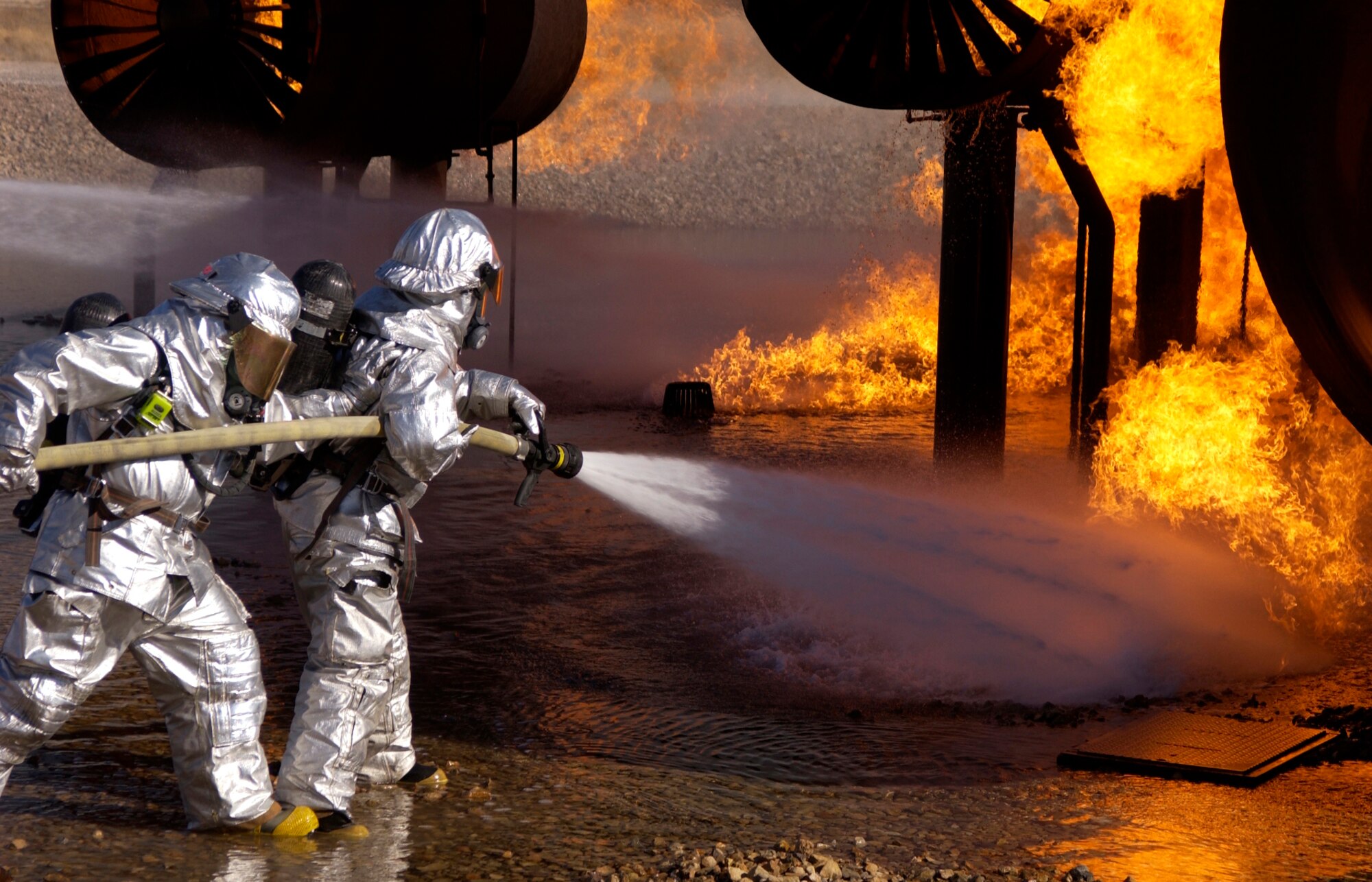 Airmen from the 99th Civil Engineer Squadron Fire Protection Flight conduct their annual training on a simuated crashed aircraft at Nellis Air Force Base, Nev. Oct. 17.  Airmen in the Fire Protection Flight are required to do this training, which simulates combating both an exterior fire and interior fire, once a year(U.S.Air Force photo by Airman 1st Class Ryan Whitney)