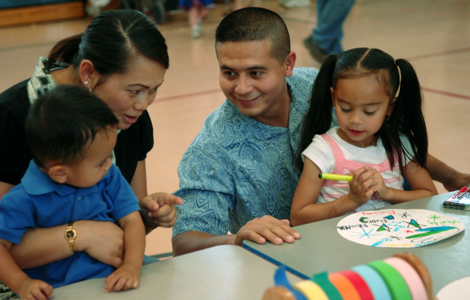 Staff Sgt. Tony Sepongviwat, electrical power production journeyman with the 820th RED HORSE squadron, and wife Vanessa share their arts and craft skills with their son and daughter, 22-month-old Balamy and 7-year-old Vanida, at the Harvest Festival at the Nellis Air Force Base Youth Center Oct. 27. The Harvest Festival is an annual event at the Youth Center. The event featured a variety of games and prizes.
(U.S Air Force photo by Stephanie Rubi)