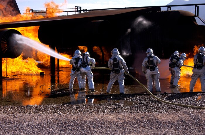Airmen from the 99th Civil Engineer Squadron Fire Protection Flight conduct their annual training on a simuated crashed aircraft at Nellis Air Force Base, Nev. Oct. 17.  Airmen in the Fire Protection Flight are required to do this training, which simulates combating both an exterior fire and interior fire, once a year(U.S.Air Force photo by Airman 1st Class Ryan Whitney)