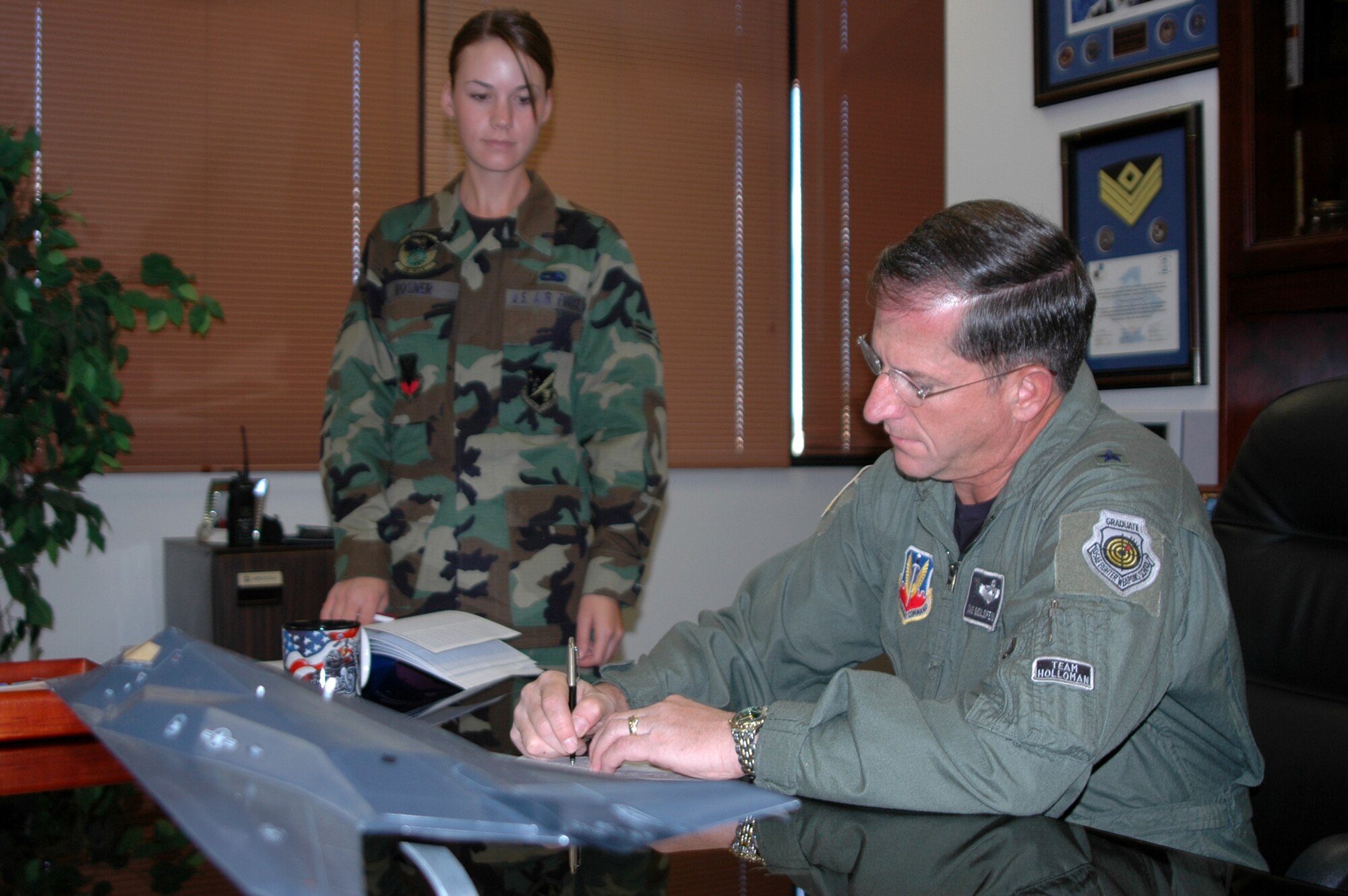 Airman 1st Class Amanda Rosner, 49th Maintenance Squadron, looks on as Brig. Gen. David Goldfein, 49th Fighter Wing commander, signs a Combined Federal Campaign voucher during Holloman Air Force Base’s annual CFC campaign. The CFC is the world’s largest and most successful annual workplace charity campaign, with more than 300 CFC campaigns throughout the country and internationally to help to raise millions of dollars each year. Pledges made by federal civilian, postal and military donors during the campaign season support eligible non–profit organizations that provide health and human service benefits throughout the world. Holloman’s campaign began Oct. 18 and will run through Nov. 28. (U.S. Air Force photo/Capt. Warren Comer)
