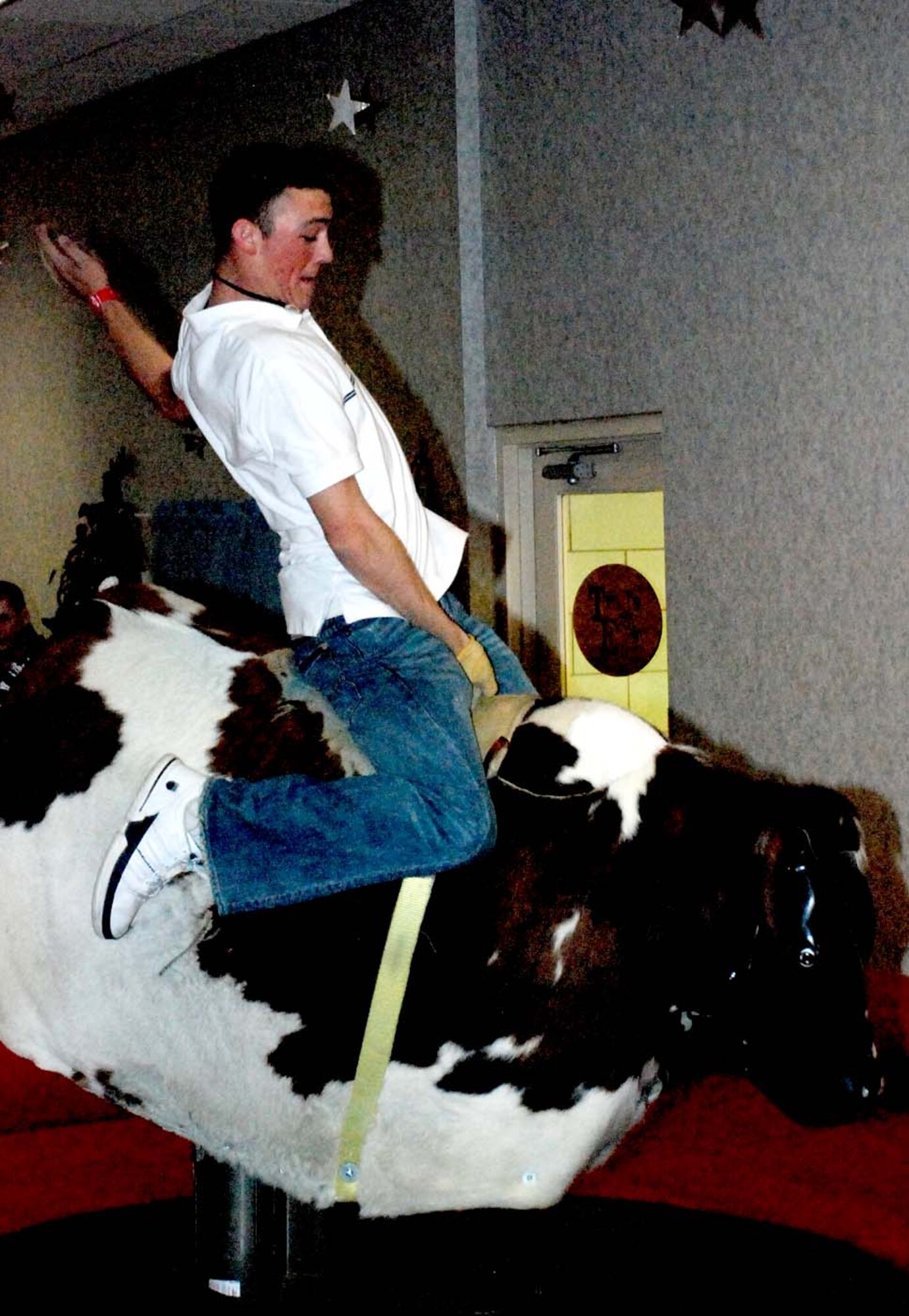 Airman 1st Class John Medley, 90th MSFS, rides a mechanical bull during the 90th SFG Club Warren night Oct. 19.