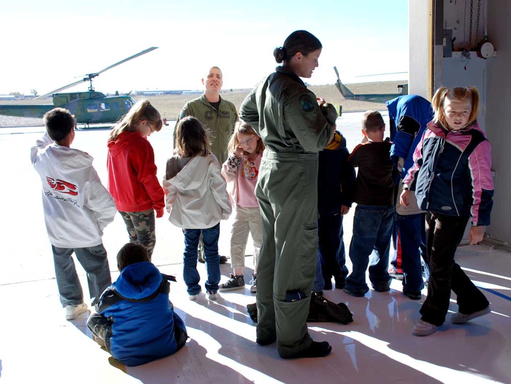 Second Lt. Heather Smith and Senior Airman Matt Fields, 37th Helicopter Squadron, educate third grade students of Fairview Elementary Monday. The children were able to see a helicopter take off, and also got to see the base museum, security forces weapons and simulated missile launches (Photo by Airman 1st Class Alex Martinez).