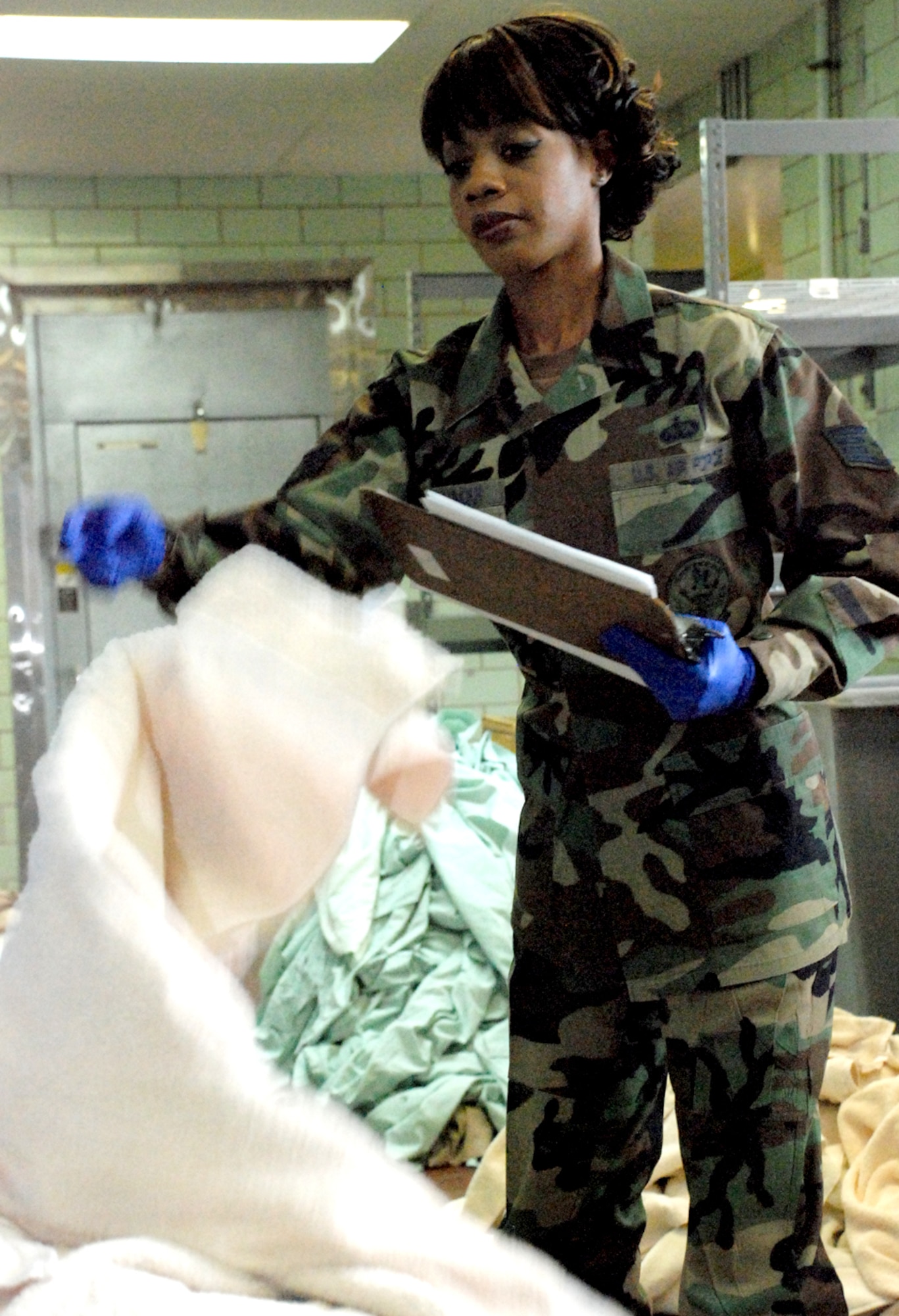 Staff Sgt. Lakeisha El Halloui, 90th Force Support Squadron, counts linen before the contractor arrives Oct. 17. Sergeant El Halloui’s job entails checking and logging any damage done to the linen before it’s shipped off to be cleaned (Photo by Airman 1st Class Daryl Knee).