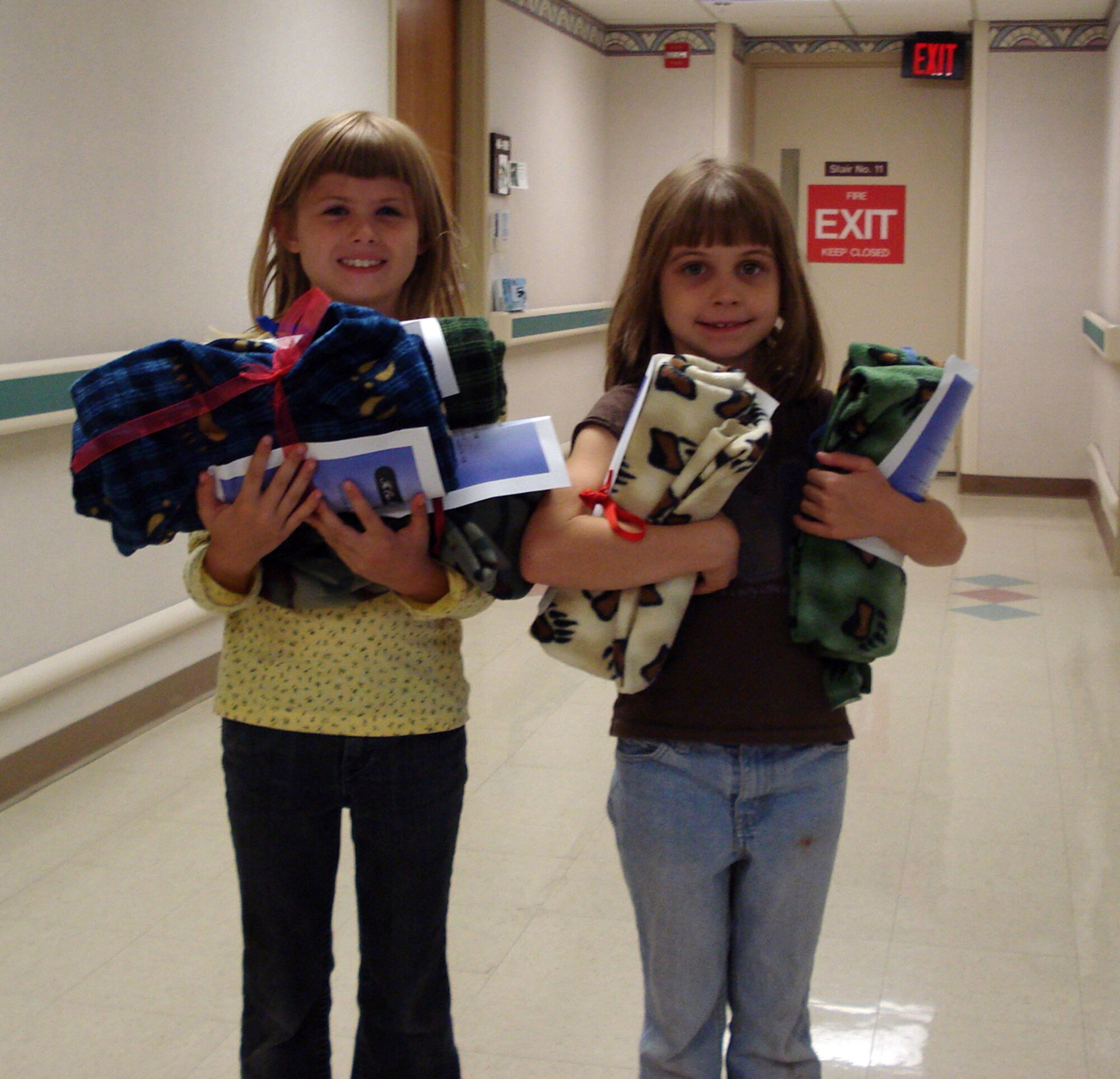 Kaitlyn Colleary and Kasey Colleary, daughters of Kristine Colleary, Computer Sciences Corporation, deliver lap blankets to veterans for Make a Difference Day Oct. 27. The Vance Youth Center children made more than 100 blankets for veterans at the Oklahoma City VA Medical Center. (Courtesy photo)