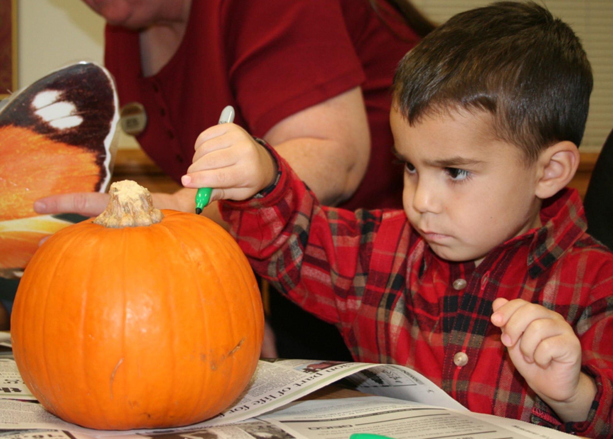 Joey Rodriquez, 3, concentrates on decorating his pumpkin at the Hearts Apart Hobo Night Oct. 26. at the Airman & Family Readiness Center. The event was thrown by the A&FRC as a Halloween-alternative theme party designed to get family members of deployed and remotely assigned Airmen together for a night of fun. (U.S. Air Force photo by Tech. Sgt. Angela Shepherd)