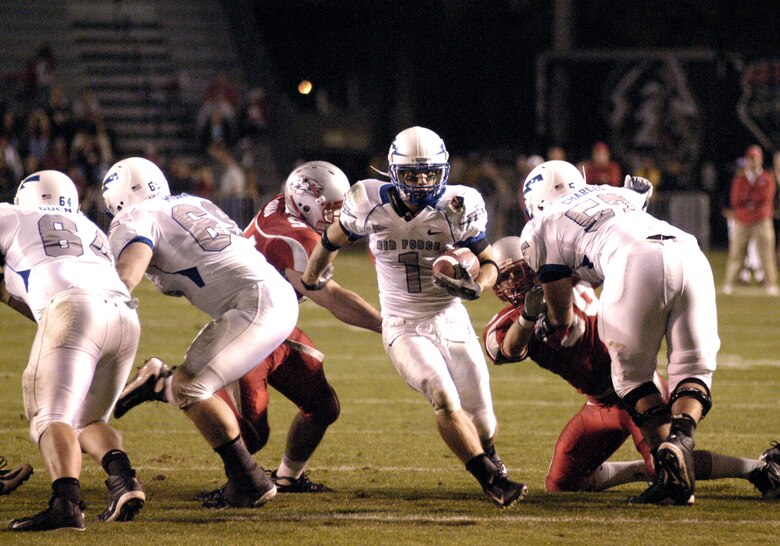 Falcon z-back Chad Hall darts through a hole made by his offensive line during Air Force's 34-31 loss to New Mexico Oct. 25 at University Stadium in Albuquerque. Hall recovered from stomach flu earlier in the week to rush for a team-high 97 yards and catch six passes for 66 yards. (U.S. Air Force photo/John Van Winkle) 
