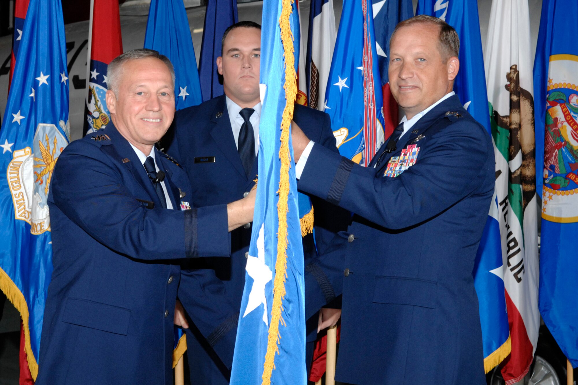 EGLIN AIR FORCE BASE, Fla. -- Gen. Bruce Carlson, Air Force Material Command commander, passes the two-star flag to Maj. Gen. David Eidsaune at General Eidsaune's promotion ceremony Oct. 26.