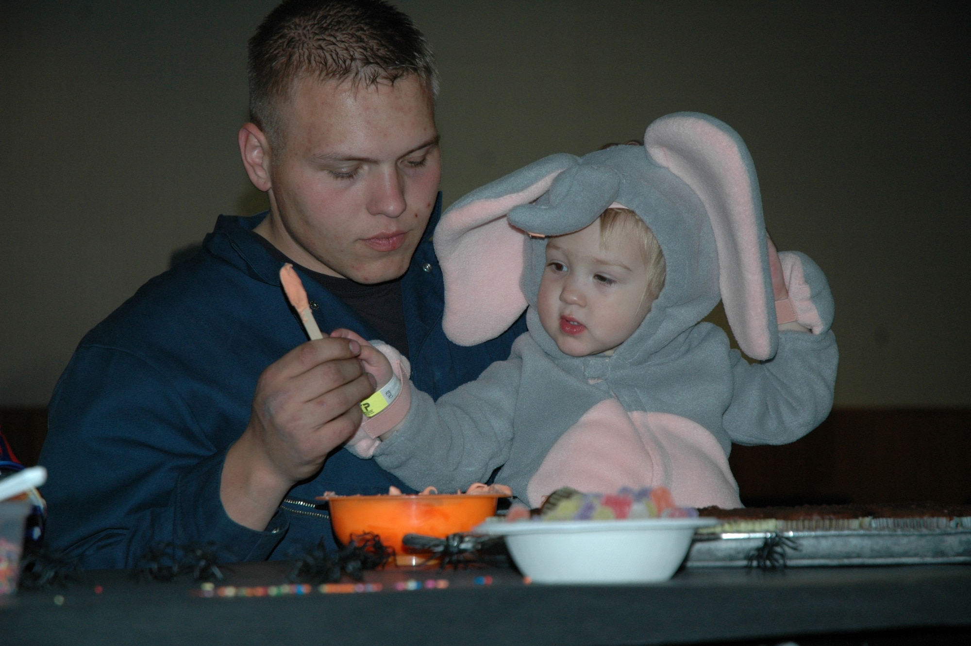 Senior Airman Joe Walter, 341st Logistics Readiness Squadron, helps Little Warrior Haley, 2, frost cupcakes. Frosting and other toppings were provided for the children to decorate their own cupcakes at the Youth Programs Center's Fall Festival Oct. 26. (U.S. Air Force photo/Airman 1st Class Emerald Ralston)