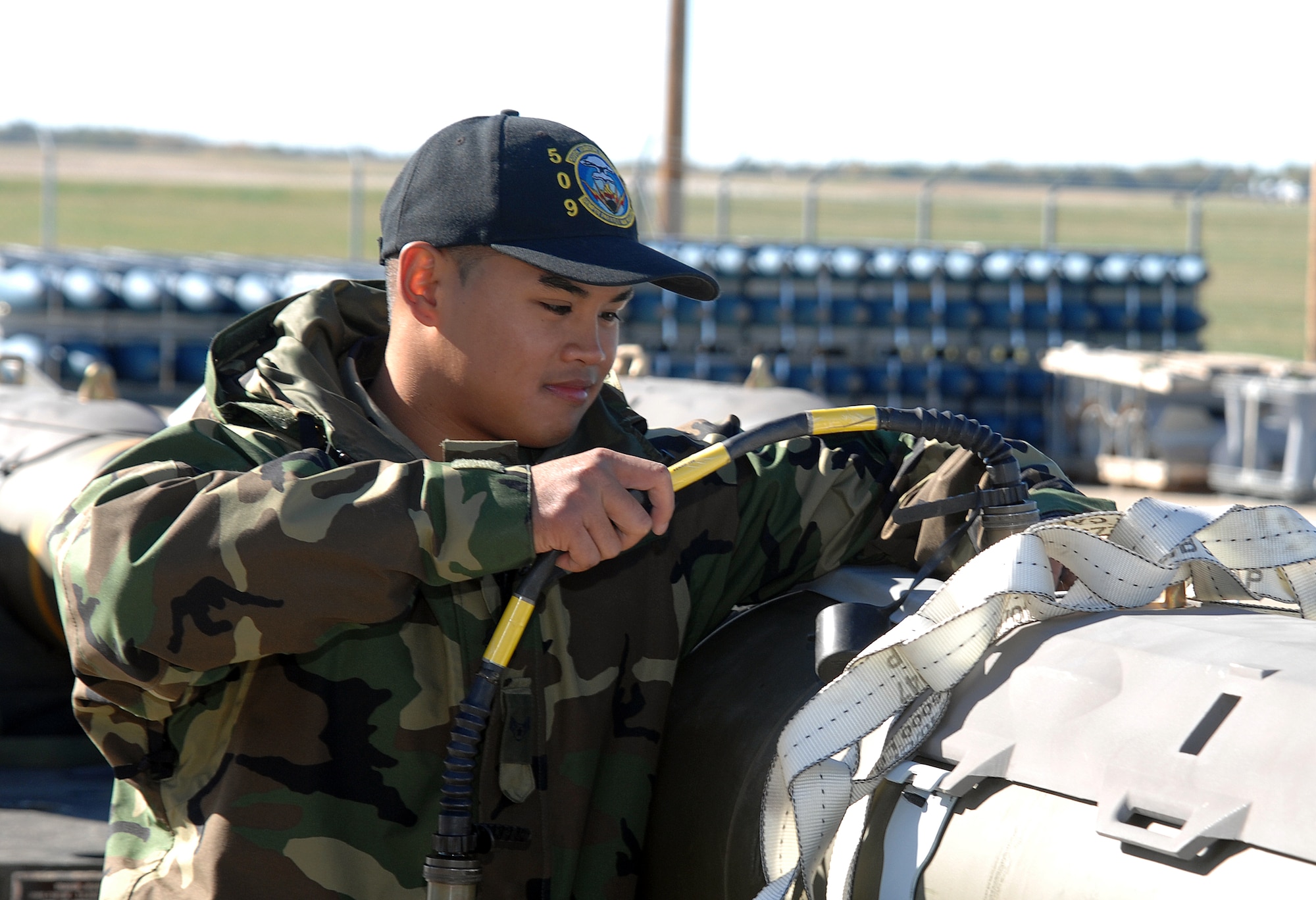 WHITEMAN AIR FORCE BASE, Mo. -- Airman 1st Class Mark Cruz, 509th Munitions Squadron, attaches a test set cable to the umbilical connection on the Joint Direct Attack Munitions to allow for a software upgrade Oct. 24. (U.S. Air Force photo/Tech. Sgt. Samuel A. Park)