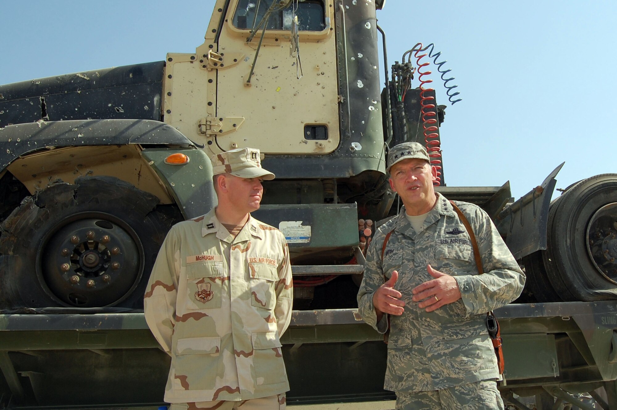 SOUTHWEST ASIA -- Capt. Joseph McHugh, 70th Medium Truck Detachment, detachment commander listens as Lt. Gen. Gary North, 9th Air Force and U.S. Central Command Air Forces commander, explains the importance of up-armored vehicles Oct. 26 at an undisclosed location. The vehicle behind them was struck by an improvised explosive device and the crew came out unharmed. (Air Force photo by Staff Sgt Phillip Butterfield)