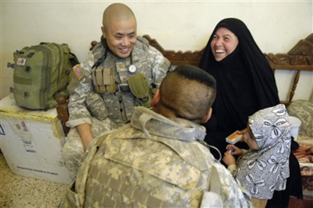 Maj. Henry Shih (left), a U.S. Army doctor, laughs with a patient during a combined medical engagement in Al Karaya, Iraq, on Oct. 17, 2007.  Shih and fellow soldiers from Headquarters Troop, 3rd Brigade Combat Team, 1st Cavalry Division, provided medical attention to Iraqis in the Al Karaya region.  