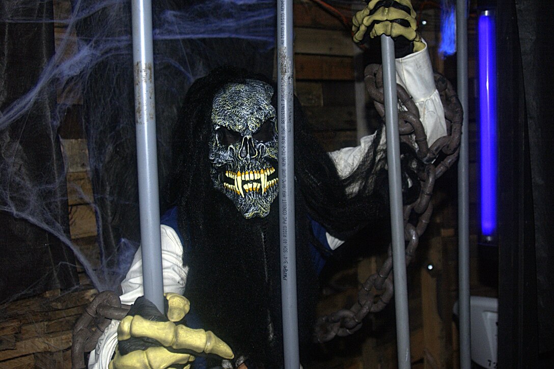 A skeletal pirate, played by Staff Sgt. Danny Jackson, 734th Air Mobility Squadron, grabbed visitors of the Haunted Trail through his prison bars Oct. 27. (U.S Air Force photo/Airman 1st Class Carissa Morgan)