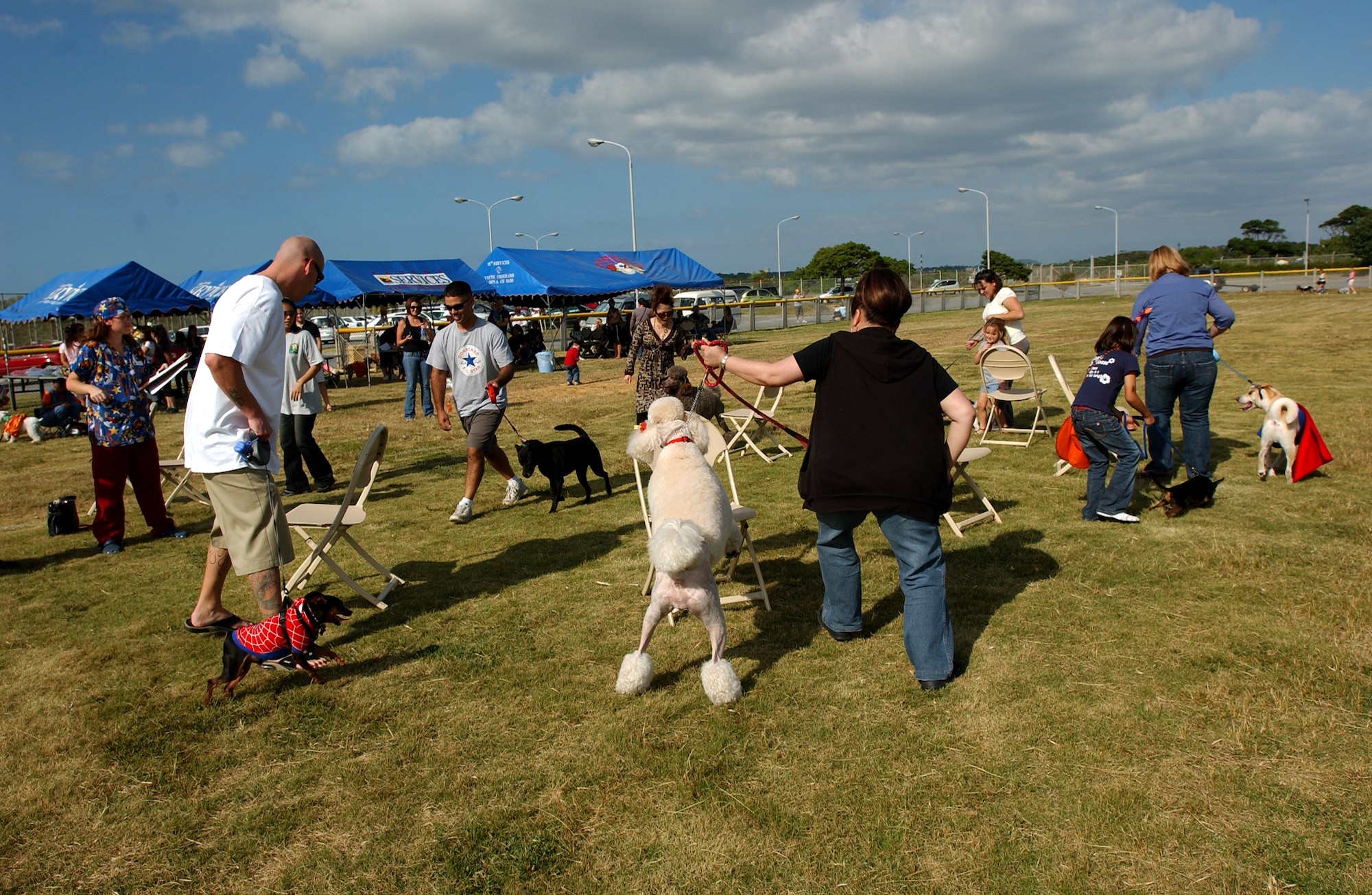 Military members and Okinawans participate in a musical chair skit with their dogs during Dogtoberfest near Chibana Golf Course, Okinawa, Japan, Oct. 28, 2007. Kadena Services held the event to get the military and local community involved by bringing out their pets and to socialize.
(U.S. Air Force photo/Tech. Sgt. Rey Ramon)
