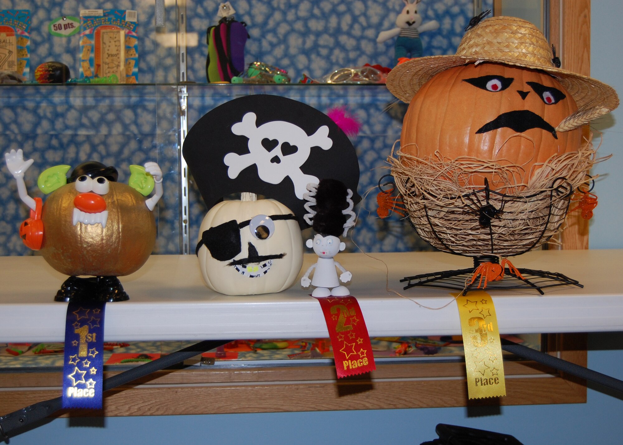EIELSON AIR FORCE BASE, Alaska-- The winning pumpkins of the Pumpkins and Poetry Festival stand on display Oct. 26 at the Crawford Elementary School. Pictured left to right are, first place: Count Pumkula by Bryon Whiting, son of Staff Sgt. Yolanda and Tech. Sgt. Anthony Whiting, both 354th Logistics Readiness Squadron. Second place: Pirate Pumpkin by Maylena Homer, daughter of Sarah and Tech. Sgt. Thomas Homer, 354th Maintenance Squadron. Third place is Farmer Bob, by Angelica Kougl, daughter of Clarissa and Patt Kougl, Crawford Elementary School faculty. (U.S. Air Force photo by Airman 1st Class Nora Anton)