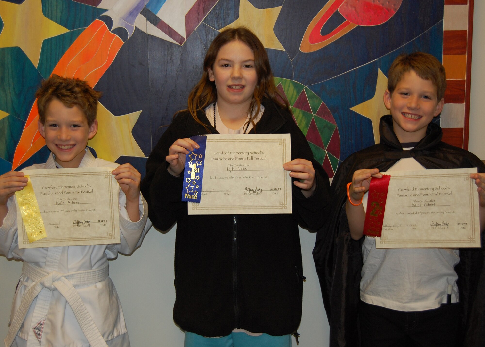 EIELSON AIR FORCE BASE, Alaska-- The winners of the poetry contest during the Pumpkins and Poetry Festival held at the Crawford Elementary School Oct. 26 pose for a photo. First place went to Kylan Nolan, daughter of Karen Nolan, 354th Civil Engineer Squadron power plant worker; Second and Third place went to Kaleb and Kyle Albert, sons of Heather and Staff Sgt. Matt Albert, 354th Contracting Squadron. (U.S. Air Force photo by Airman 1st Class Nora Anton)