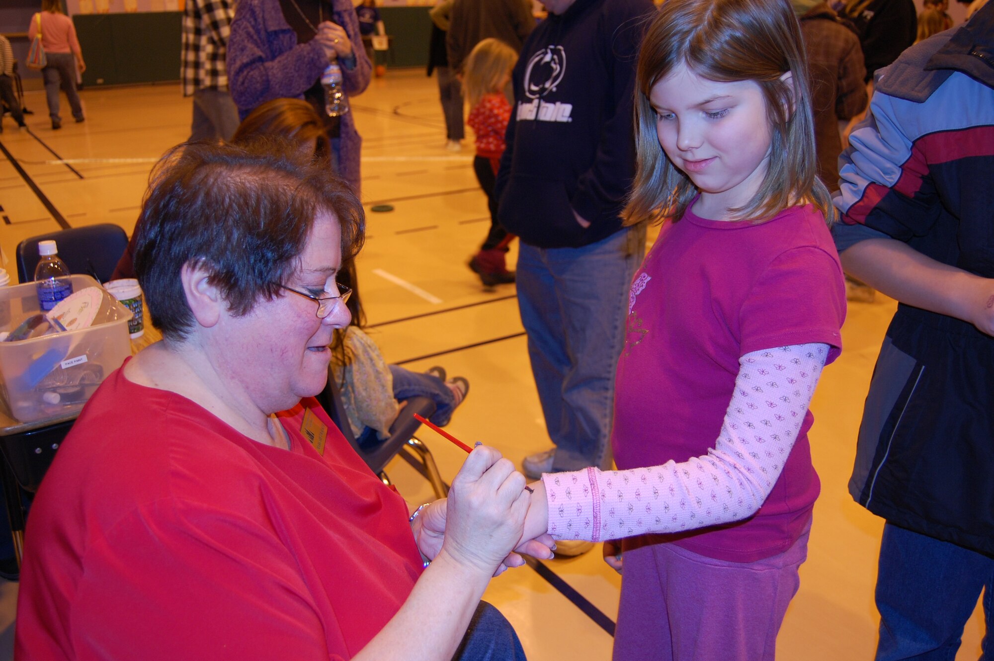 EIELSON AIR FORCE BASE, Alaska-- Grace Wilson, daughter of Melissa and Senior Master Sgt. Jeffery Wilson, 354th Maintenance Squadron first sergeant, gets a design painted on her hand by Margaret Walker, Crawford Elementary School faculty member, Oct. 26 during the Pumpkins and Poetry Festival. Children enjoyed games, candy prizes, snacks and voting for their favorite pumpkin. (U.S. Air Force photo by Airman 1st Class Nora Anton)