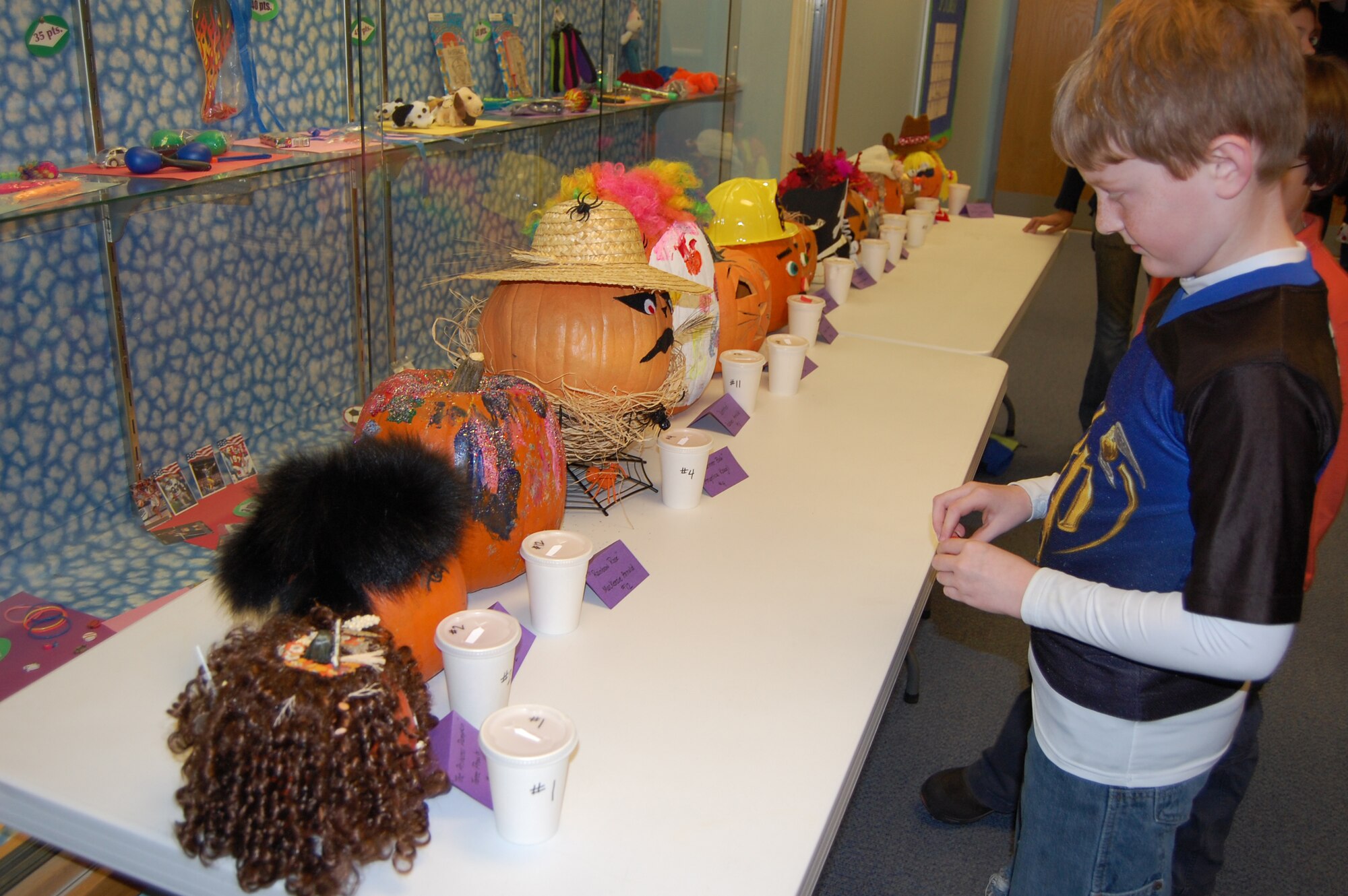 EIELSON AIR FORCE BASE, Alaska-- Matt Jordan, son of Denise and Capt. Bart Jordan, 354th Communications Squadron, decides which pumpkin he likes best before putting his vote in for the Pumpkins and Poetry Festival Oct. 26 at the Crawford Elementary School. The festival was sponsored by the Parent-Teacher Alliance organization, and children played games, ate snacks and won candy prizes in celebrations for Halloween. (U.S. Air Force photo by Airman 1st Class Nora Anton)