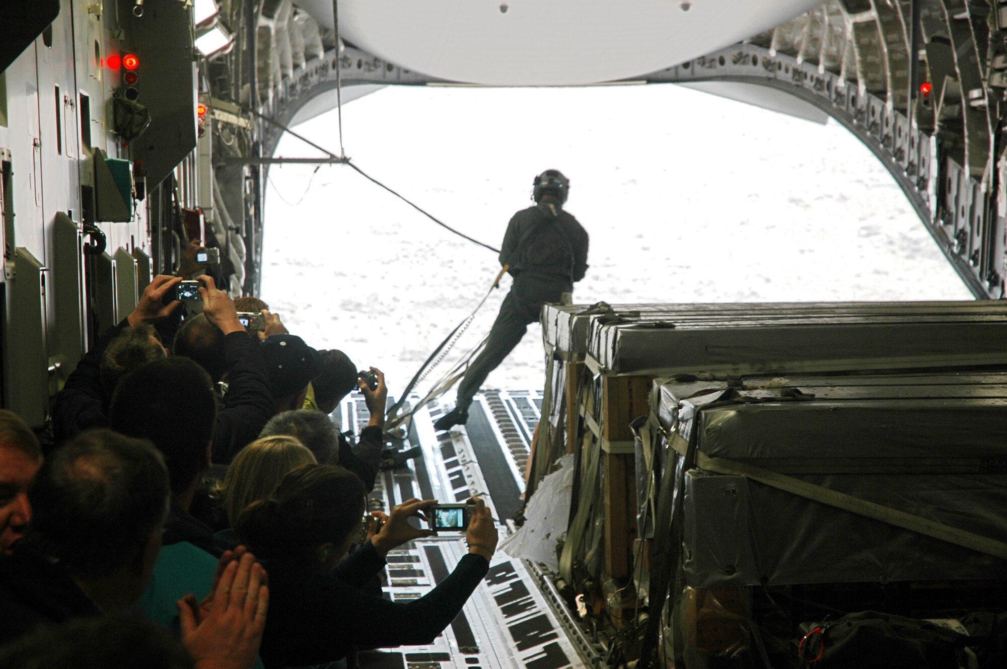 Civilian employers watch Tech. Sgt. Rob Withrow, a loadmaster in the 313th Airlift Squadron, after the  C-17 released a container delivery bundle over a drop zone Oct. 20.  The employers spent Oct. 20 learning about the mission and duties of their employees who also serve in the Air Force Reserve with the 446th Airlift Wing, McChord Air Force Base, Wash.  (U.S. Air Force photo/Senior Airman Grant Saylor)