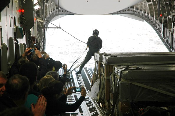 Civilian employers watch Tech. Sgt. Rob Withrow, a loadmaster in the 313th Airlift Squadron, after the  C-17 released a container delivery bundle over a drop zone Oct. 20.  The employers spent Oct. 20 learning about the mission and duties of their employees who also serve in the Air Force Reserve with the 446th Airlift Wing, McChord Air Force Base, Wash.  (U.S. Air Force photo/Senior Airman Grant Saylor)